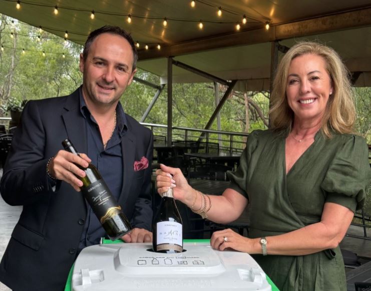 Winery owners holding wine bottles