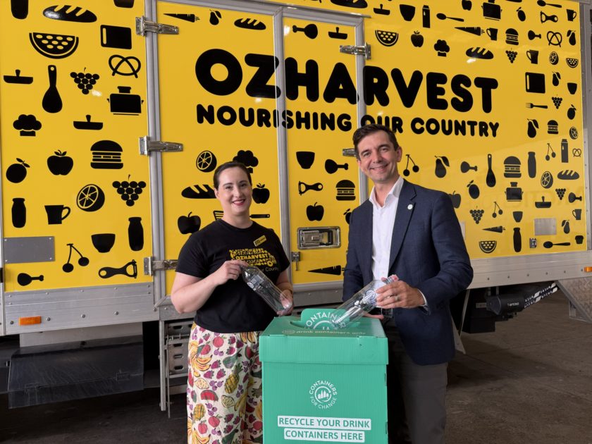 OzHarvest Queensland State Manager Michaela Windsor and Container Exchange CEO Trevor Evans standing beside a green Containers for Change collection bin in front of an OzHarvest vehicle.