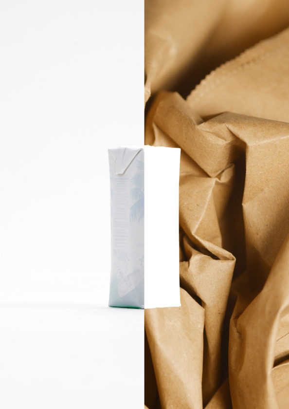 Liquid paperboard beverage carton alongside recycled paper fibres, illustrating carton recycling and resource recovery.